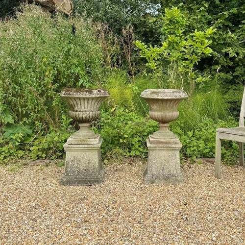 Pair of Patinated Campania Urns and Plinths