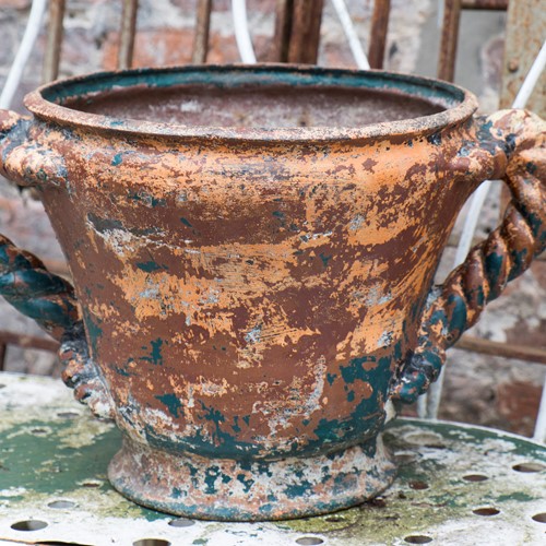 Heavy cast iron garden pot with twisted handles