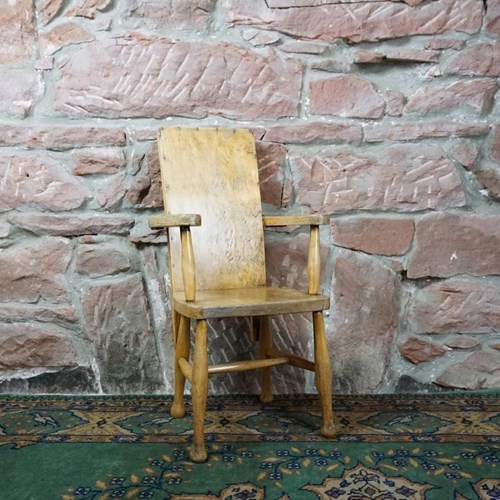 A Child's Wooden Chair With Metal Reinforcement 
