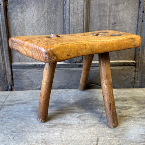 An 18Th Century Elm Stool Standing Over Three Legs